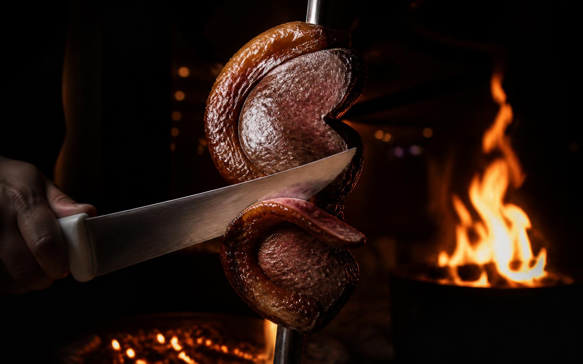 Gaucho chef slicing fire-roasted picanha tableside